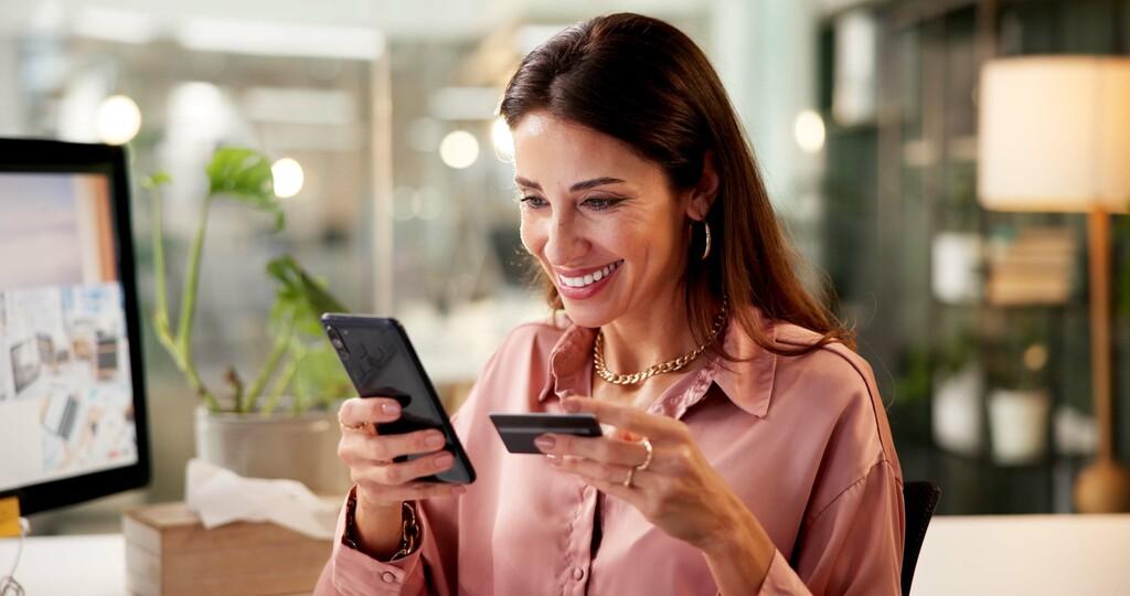 woman with a credit card buying directly from her phone.