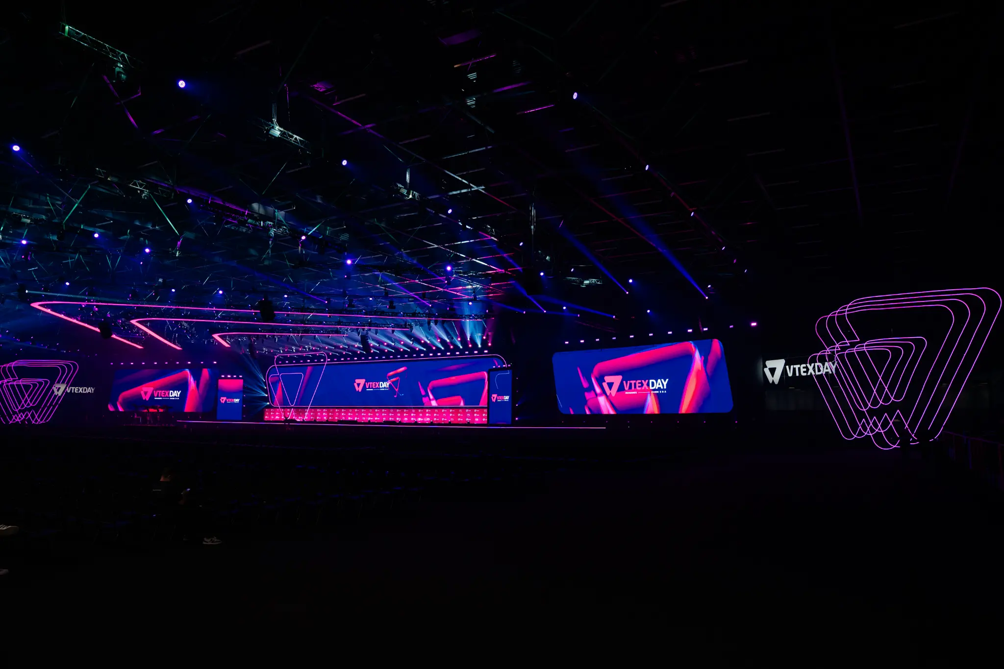 Palco principal do VTEX DAY iluminado em azul e rosa